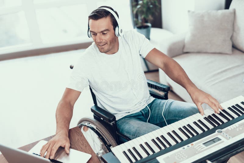 Canción que compone del hombre discapacitado con el sintetizador foto de archivo libre de regalías Canción que compone del hombre discapacitado con el sintetizador foto de archivo libre de regalías