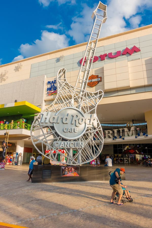 CANCUN, MEXICO - JANUARY 10, 2018: Unidentified people at outdoors next to Hard Rock Cafe metallic guitar structure in stock photo CANCUN, MEXICO - JANUARY 10, 2018: Unidentified people at outdoors next to Hard Rock Cafe metallic guitar structure in stock photo