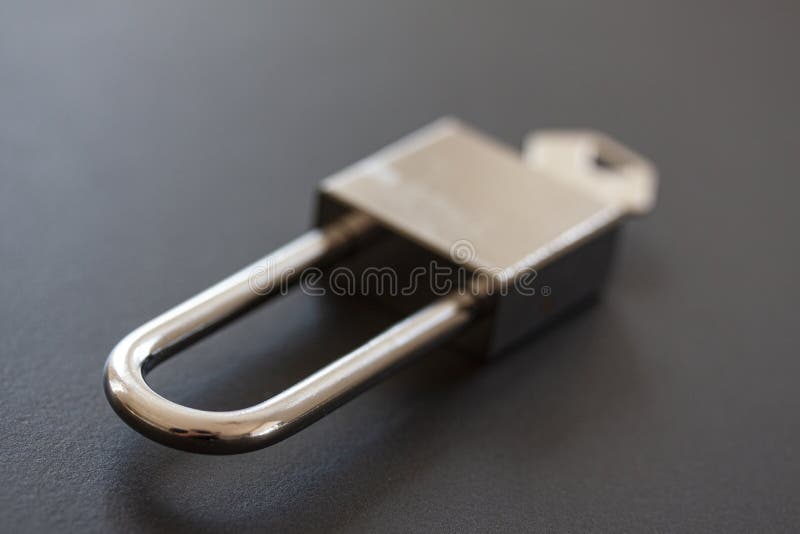 Candado de acero inoxidable con llave en fondo negro fotografía de archivo libre de regalías Candado de acero inoxidable con llave en fondo negro fotografía de archivo libre de regalías