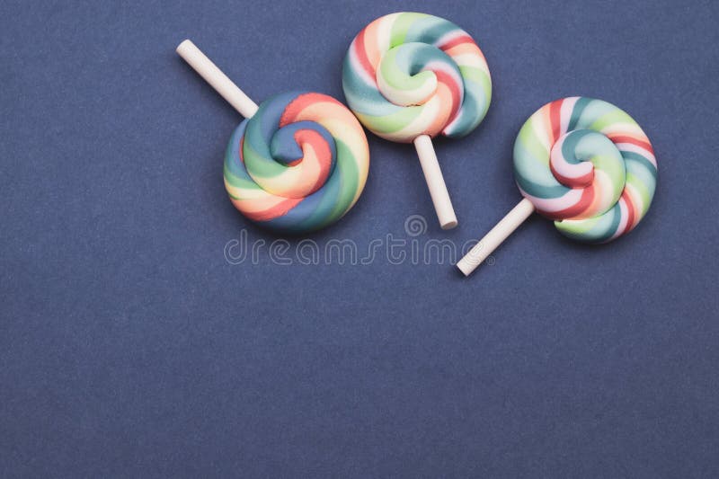 Candele colorate lollipops isolate su fondo blu concetto di festività spazio di copia. Candele colorate lecca isolata su fondo colorato concetto di festività spazio di copia