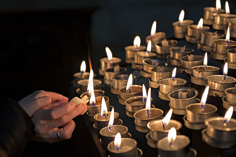 Candele di illuminazione in una chiesa immagine stock libera da diritti Candele di illuminazione in una chiesa immagine stock libera da diritti