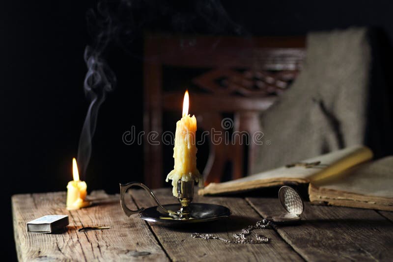 Candele sulla tavola con il libro e l'orologio da tasca fotografia stock libera da diritti