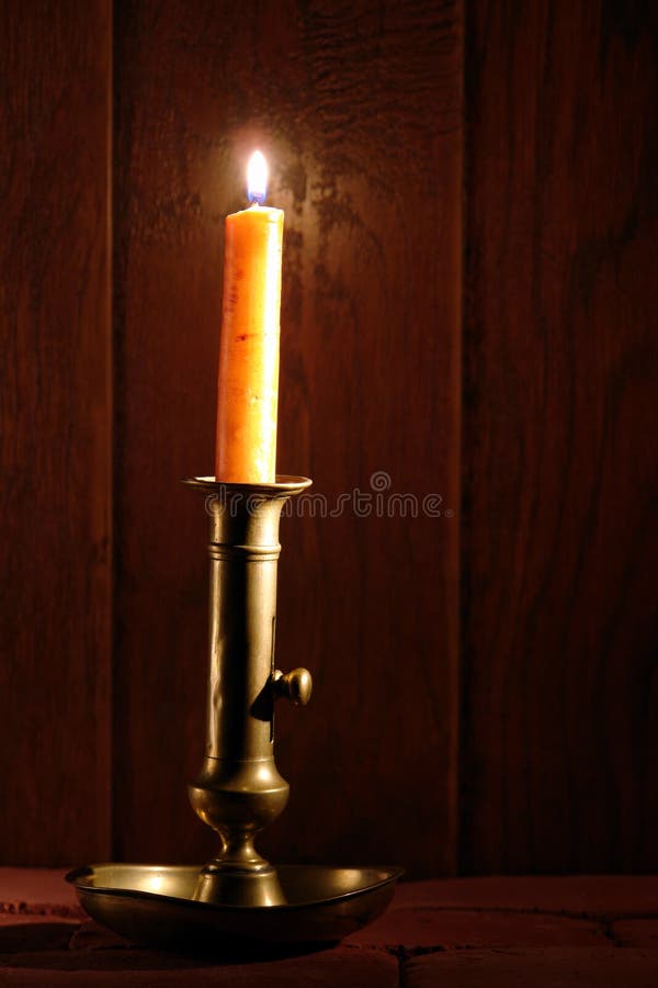 Candeliere d'ottone antico con Burning della candela immagini stock libere da diritti Candeliere d'ottone antico con Burning della candela immagini stock libere da diritti
