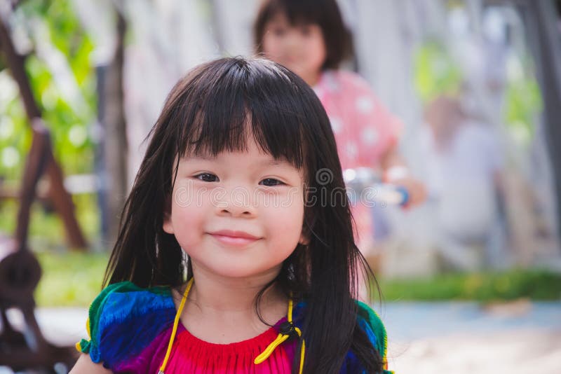 Candid image child 3-4 years old. Face sweet smile little girl in park playground. Head shot happy adorable kid Summer or spring