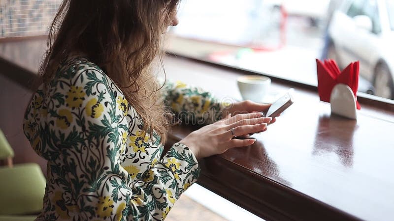 Candid image of a young woman using tablet computer in a cafe. Hot cafe video