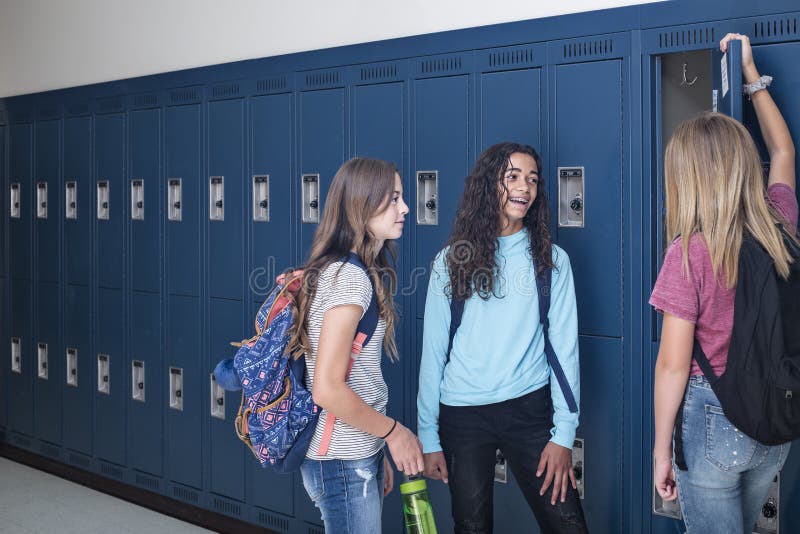 Junior High school Students talking and standing by their locker in a school hallway royalty free stock photo Junior High school Students talking and standing by their locker in a school hallway royalty free stock photo