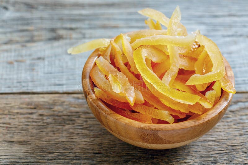 Candied orange and lemon peels on a wooden table. Candied orange and lemon peels on a wooden table.