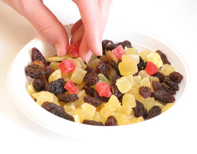 Candied peel, raisins, and women s hand.