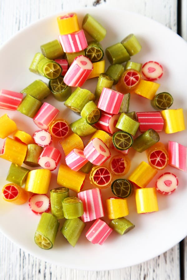 Candies. On plate on white wooden background stock images Candies. On plate on white wooden background stock images