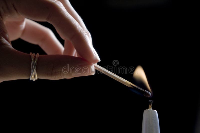 Lighting up white candle with matches