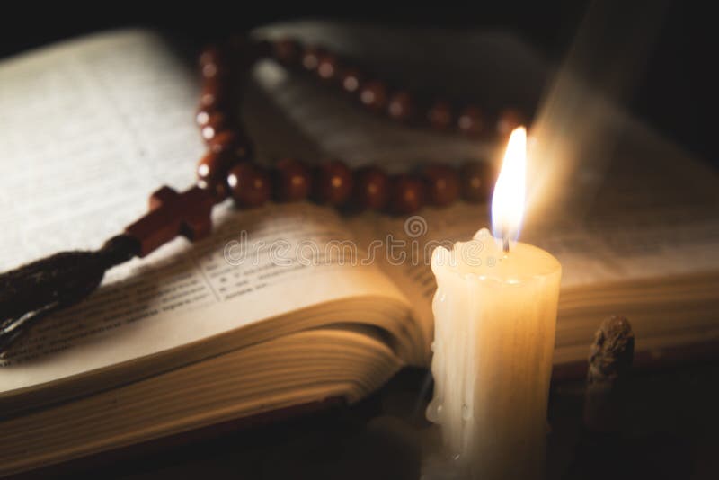 Candle with incense and holy book