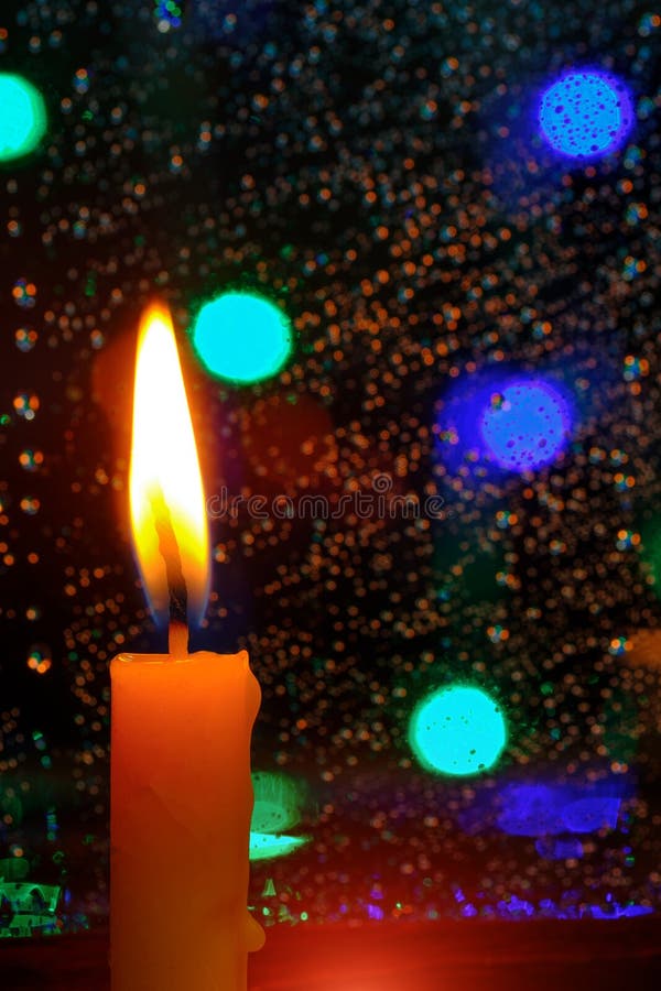 Candle Stands in Front of a Window with Rain Drops. Stock Photo Image