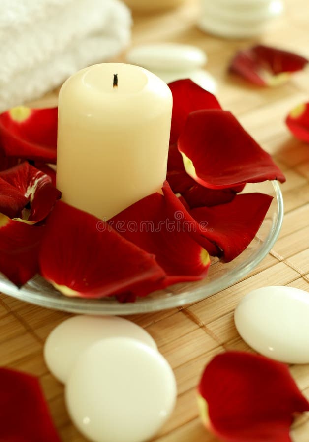 Candle, stones and petals of roses.