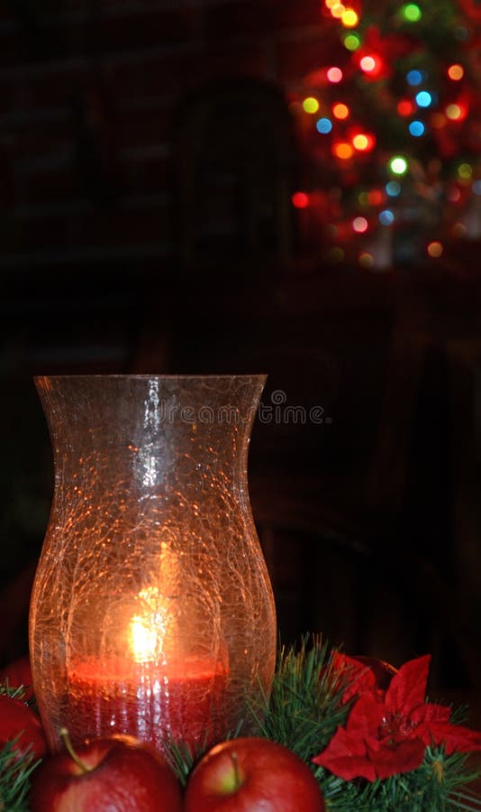 Candle Holiday Vase and Christmas Lights in Background Stock Photo