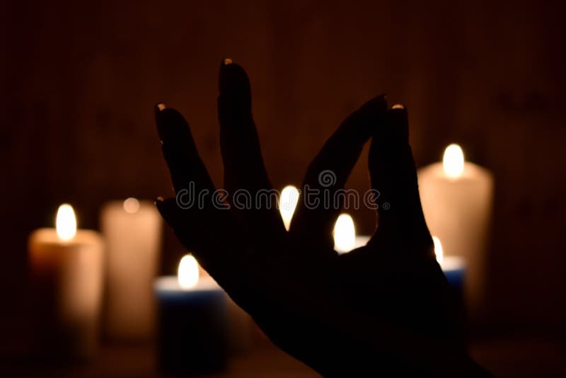 Candles and fingers mudra. Symbol of meditation folded fingers. The figure of the fingers of the mantra