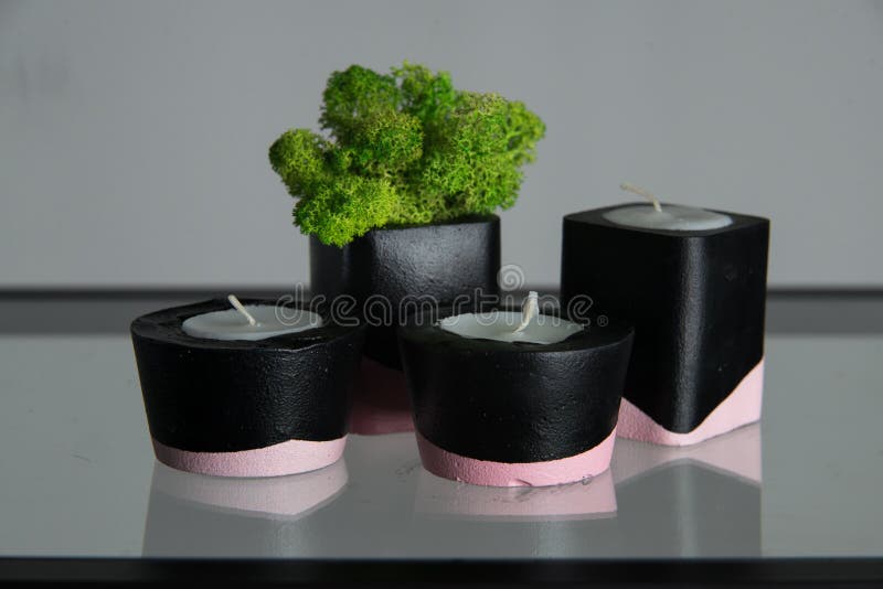 Candles and Moss in Black and Pink Concrete Candle Holders Stock Photo
