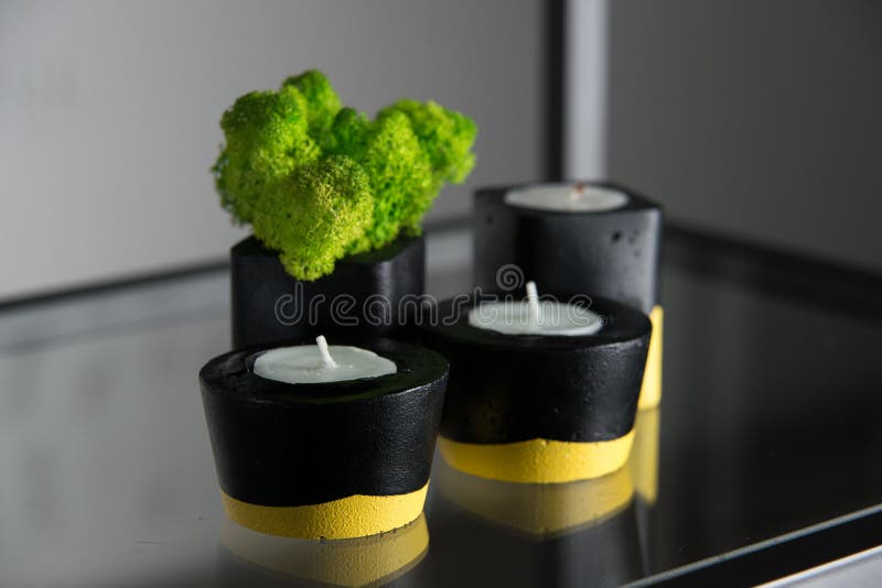 Candles and Moss in Black and Yellow Concrete Candle Holders Stock