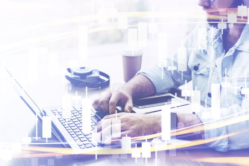 Candlestick chart in foreground. In background closeup of male hands typing on computer keyboard. Bearded man uses laptop stock photography