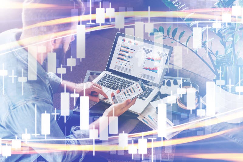 Candlestick chart on foreground. Double exposure. On background man sits, uses smartphone, working on laptop with graphs on screen royalty free stock photos