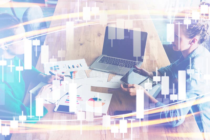 Candlestick chart on foreground. Double exposure. On background two business women sitting at table, discussing, using tablet PC royalty free stock photo