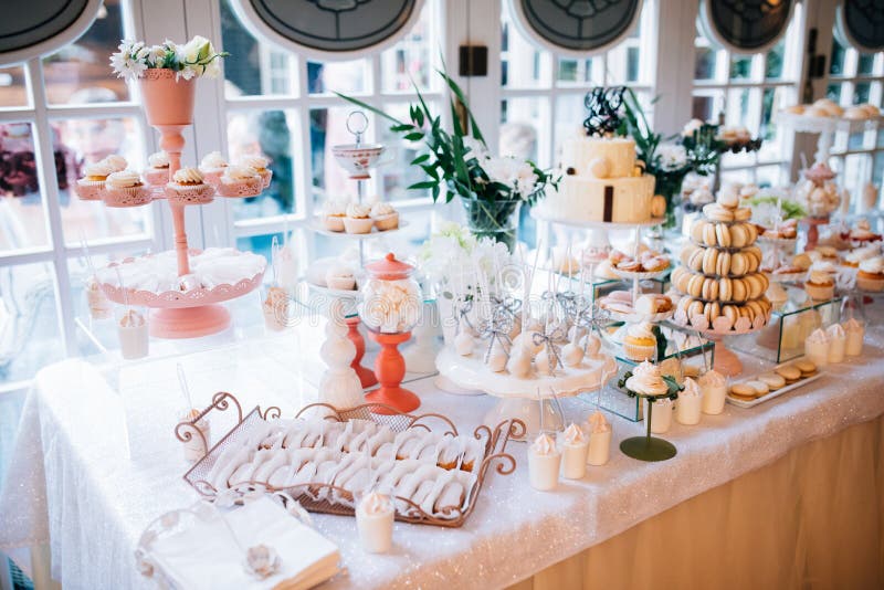 Candy bar and wedding cake with flowers. Table with sweets, buffet with cupcakes, candies, dessert. royalty free stock photo