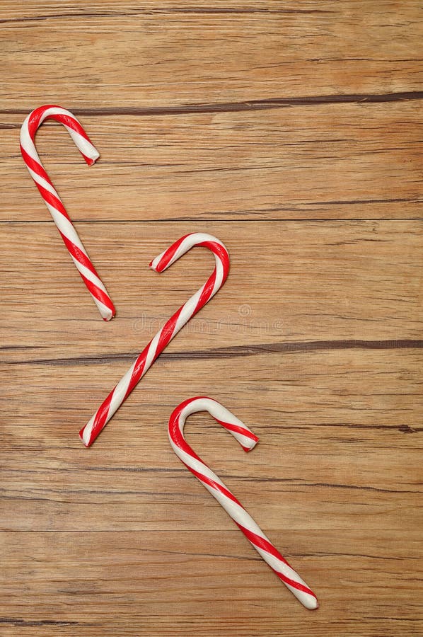 Candy canes isolated against a wooden background