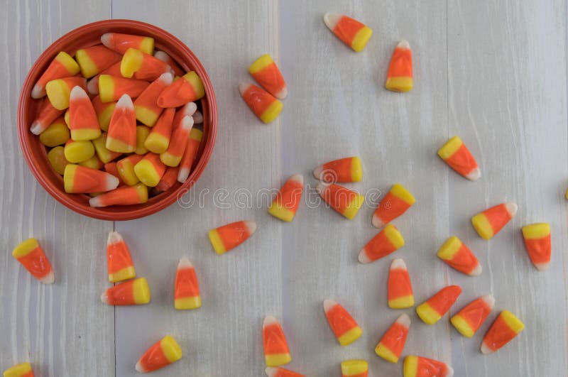 Candy Corn in Orange Bowl with Mess Spill Over stock photo Candy Corn in Orange Bowl with Mess Spill Over stock photo