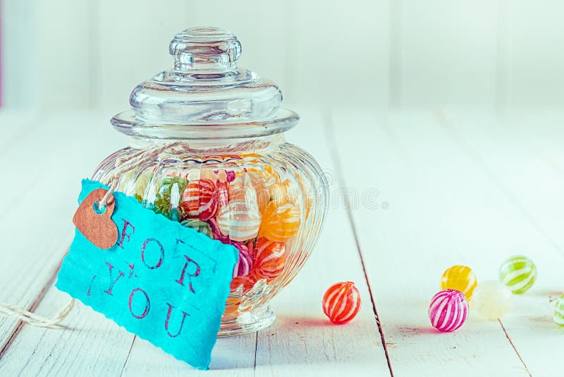 Candy jar filled with candies with a blue tag