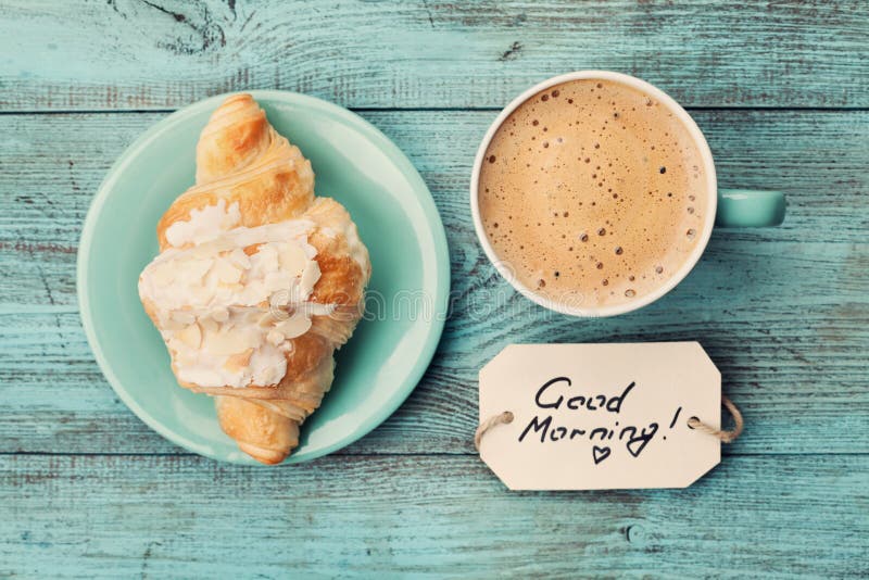 Caneca de café com bom dia do croissant e das notas na tabela rústica de turquesa de cima de, café da manhã acolhedor e saboroso