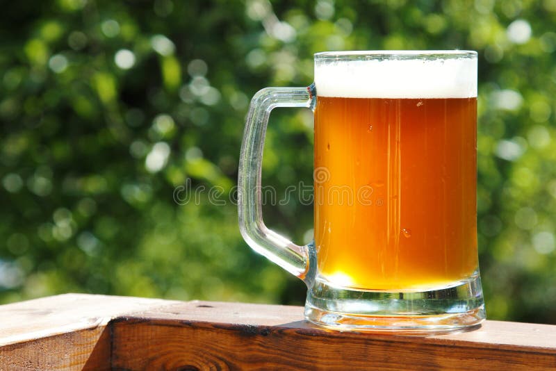 Cold beer glass mug in sunny summer day. Cold beer glass mug in sunny summer day