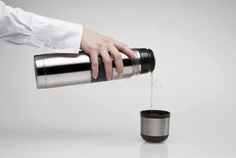 Female hand pouring tea from thermos. Female hand pouring tea from thermos