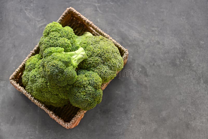 Canestro con i broccoli verdi freschi sulla tavola grigia immagini stock Canestro con i broccoli verdi freschi sulla tavola grigia immagini stock
