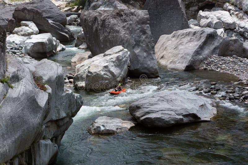 Kayaker on the rapids of cangrejal river flanked by gigantic volcanic rock blocks. Kayaker on the rapids of cangrejal river flanked by gigantic volcanic rock blocks