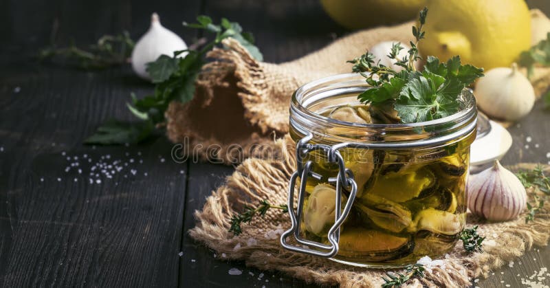 Canned mussels in olive oil and lemon juice with spices, garlic and herbs, black wooden kitchen table, selective focus royalty free stock photos Canned mussels in olive oil and lemon juice with spices, garlic and herbs, black wooden kitchen table, selective focus royalty free stock photos