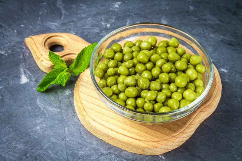 Canned Peas in a Wooden Plate on a Gray Concrete Background. Stock ...