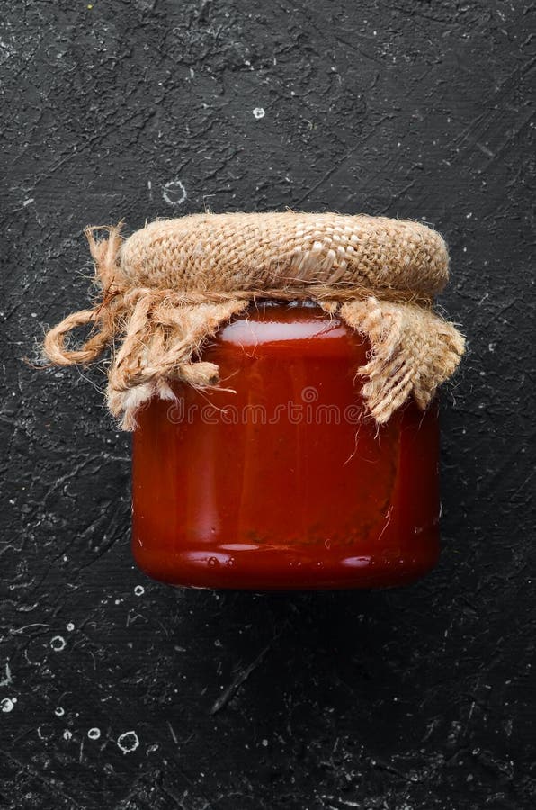 Canned tomato chili sauce in a glass jar.