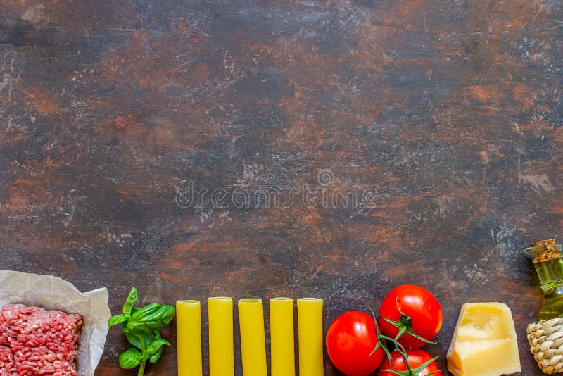 Cannelloni, pomodori, carne tritata ed altri ingredienti Fondo scuro Cucina italiana immagini stock Cannelloni, pomodori, carne tritata ed altri ingredienti Fondo scuro Cucina italiana immagini stock