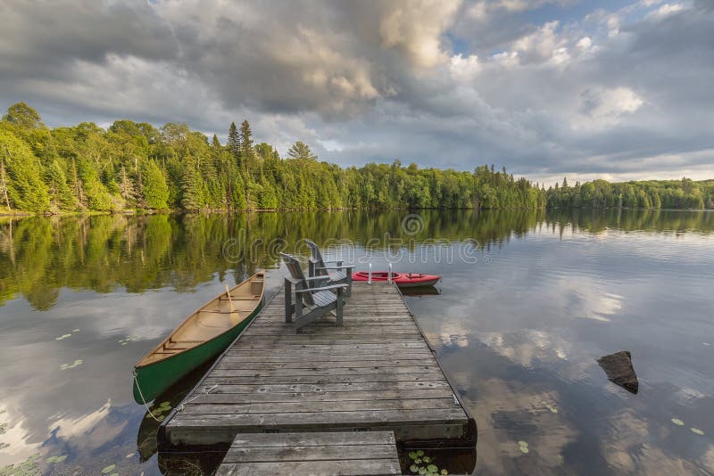 Canoa e kajak legati ad un bacino su un lago in Ontario Canada fotografie stock libere da diritti Canoa e kajak legati ad un bacino su un lago in Ontario Canada fotografie stock libere da diritti