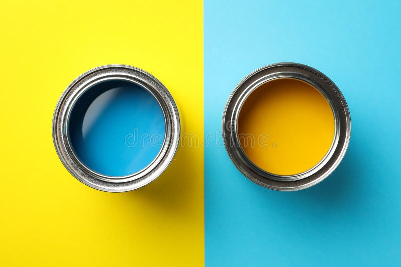 Cans of Blue and Yellow Paint on Two Tone Background Stock Photo