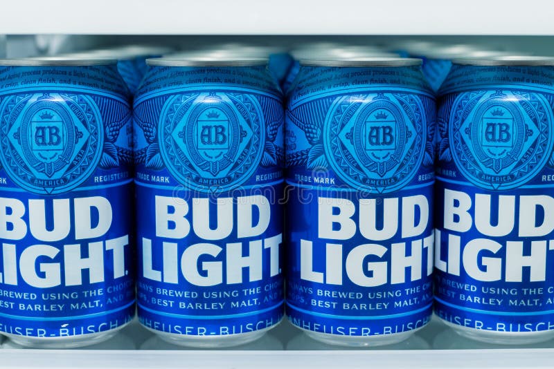 Cans of Bud Light Beer lined up on a shelf in a refrigerator.