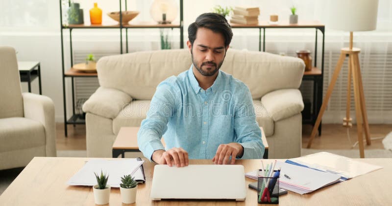 Cansado empresario usando el teléfono móvil después de terminar el trabajo en el portátil