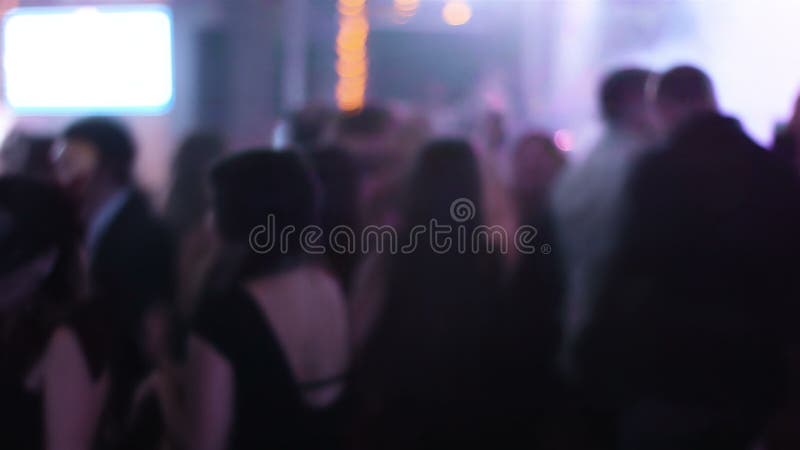 Cantidad borrosa del pasillo apretado en el club de noche con el baile de gente joven alrededor de los estudiantes que cuelgan ha