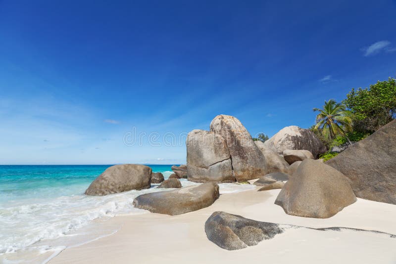 Seascape with large granite boulders and blue summer sky. Carana beach view of Seychelles. Seascape with large granite boulders and blue summer sky. Carana beach view of Seychelles