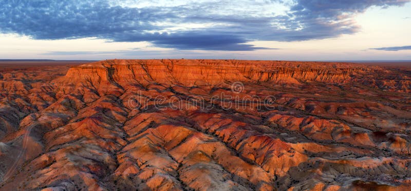 Aerial panorama of textural colorful striped canyons Tsagaan suvarga - White stupa at sunrise. Ulziit soum, Dundgovi province, Mongolia. Aerial panorama of textural colorful striped canyons Tsagaan suvarga - White stupa at sunrise. Ulziit soum, Dundgovi province, Mongolia