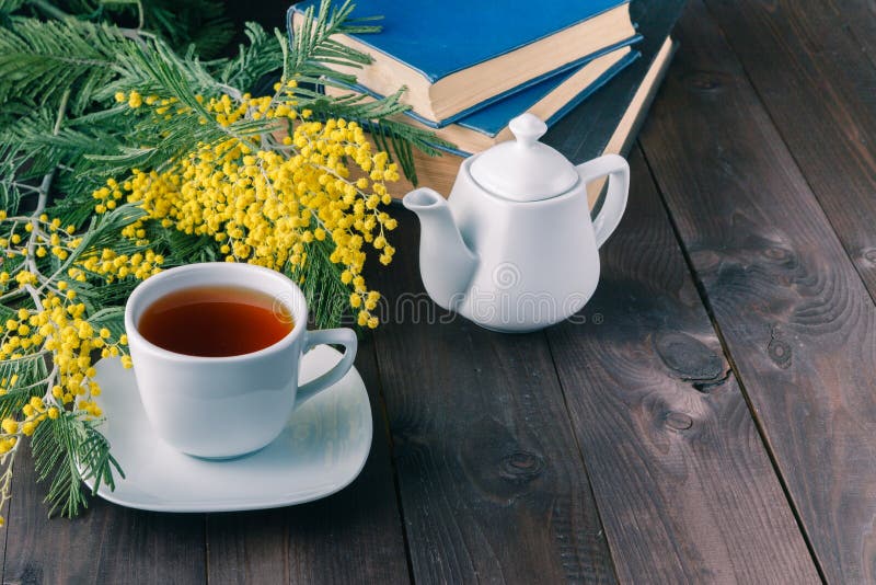 Cap of tea and book on the table top