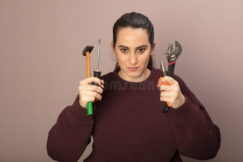 Capable young woman holding a set of tools
