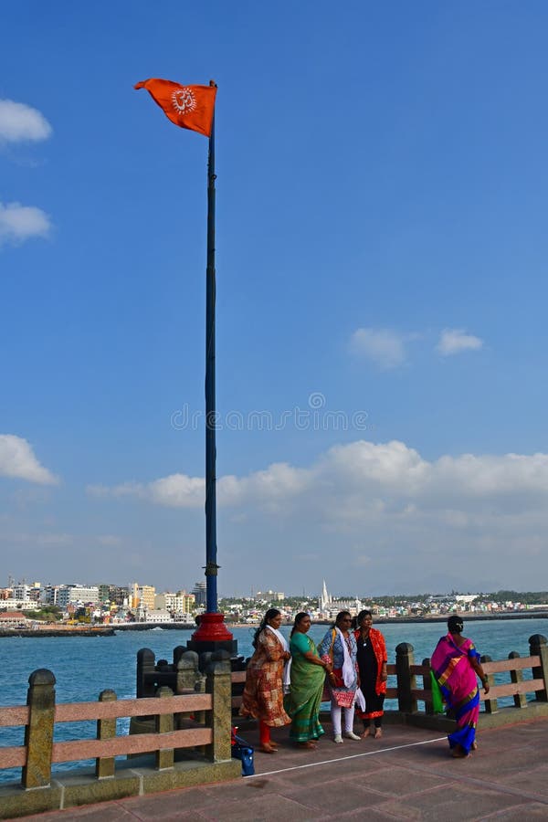 Cape Comorin Kanyakumari, India, West Bengal Tamil Nadu, March, 15, 2019. Indian women under a red flag with a sign of Ohm royalty free stock photos Cape Comorin Kanyakumari, India, West Bengal Tamil Nadu, March, 15, 2019. Indian women under a red flag with a sign of Ohm royalty free stock photos