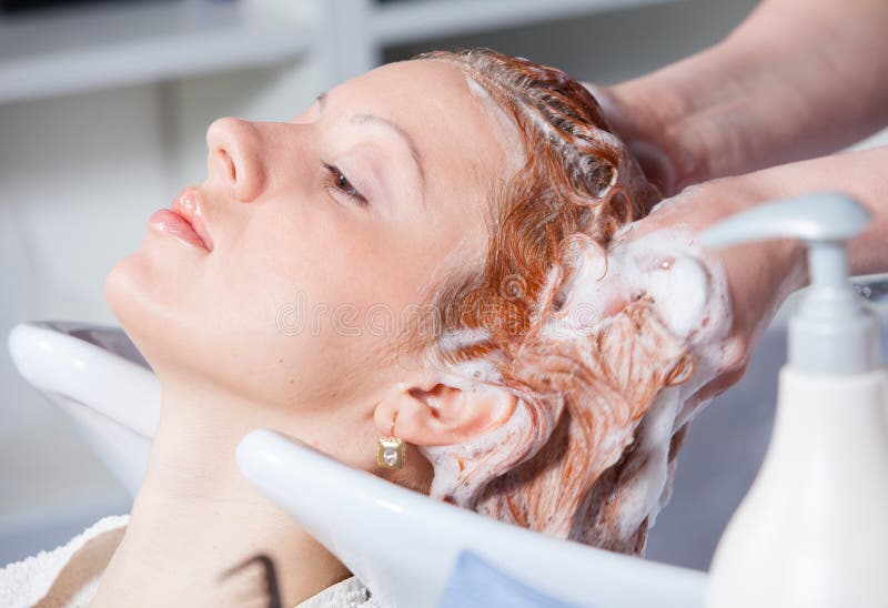 Capelli che lavano ad un salone di lavoro di parrucchiere immagine stock Capelli che lavano ad un salone di lavoro di parrucchiere immagine stock