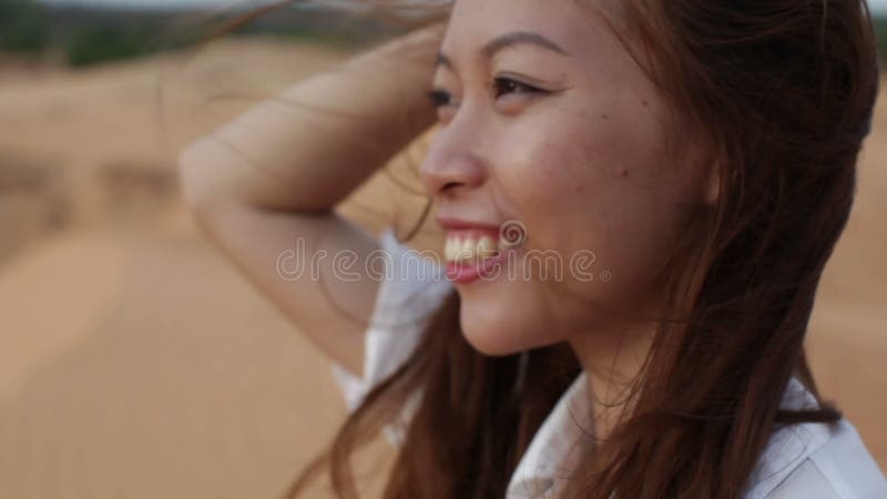 Capelli di salto della donna di sorriso del vento all'aperto asiatico del deserto