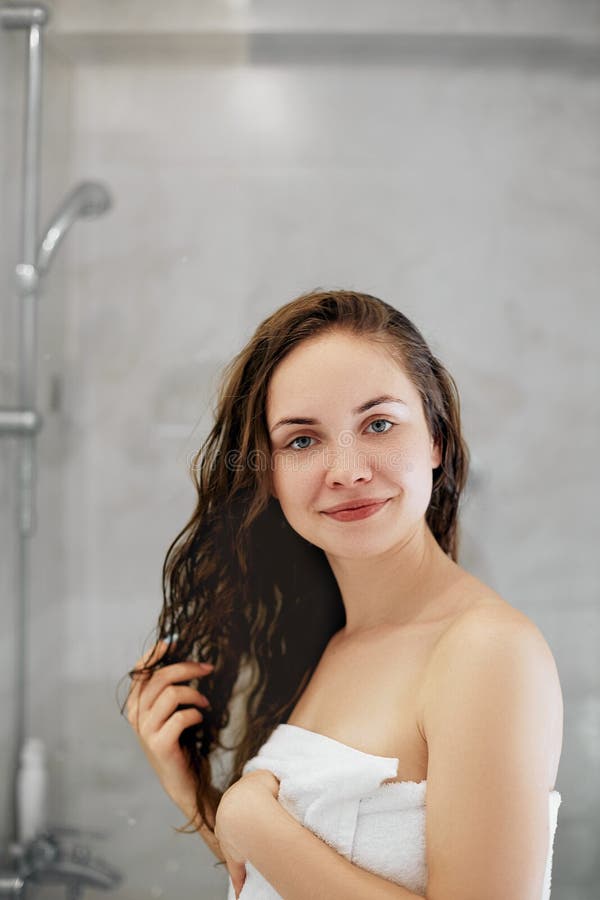 capelli Ragazza che tocca i suoi capelli ed attimo sorridente che guardano nello specchio Ritratto della giovane donna felice con fotografia stock libera da diritti capelli Ragazza che tocca i suoi capelli ed attimo sorridente che guardano nello specchio Ritratto della giovane donna felice con fotografia stock libera da diritti